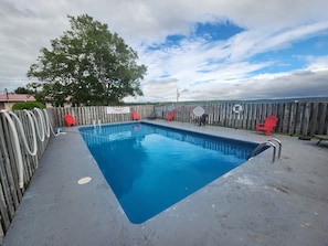 A rectangular swimming pool with a wooden deck and a metal ladder. - Trailsman Lodge  (Nyanza)