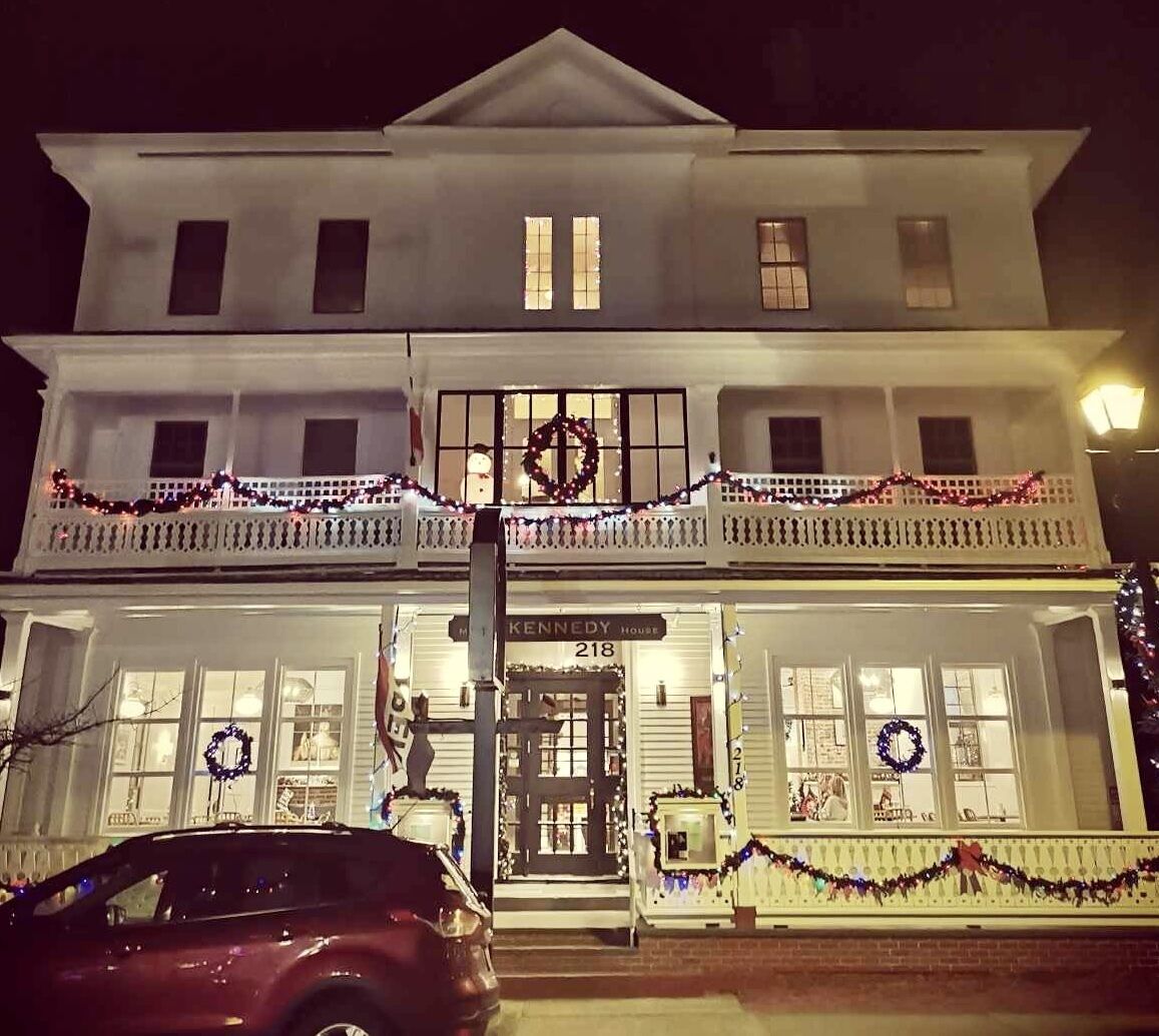 Un bâtiment à deux étages doté d’un balcon, décoré de guirlandes et de couronnes de Noël.