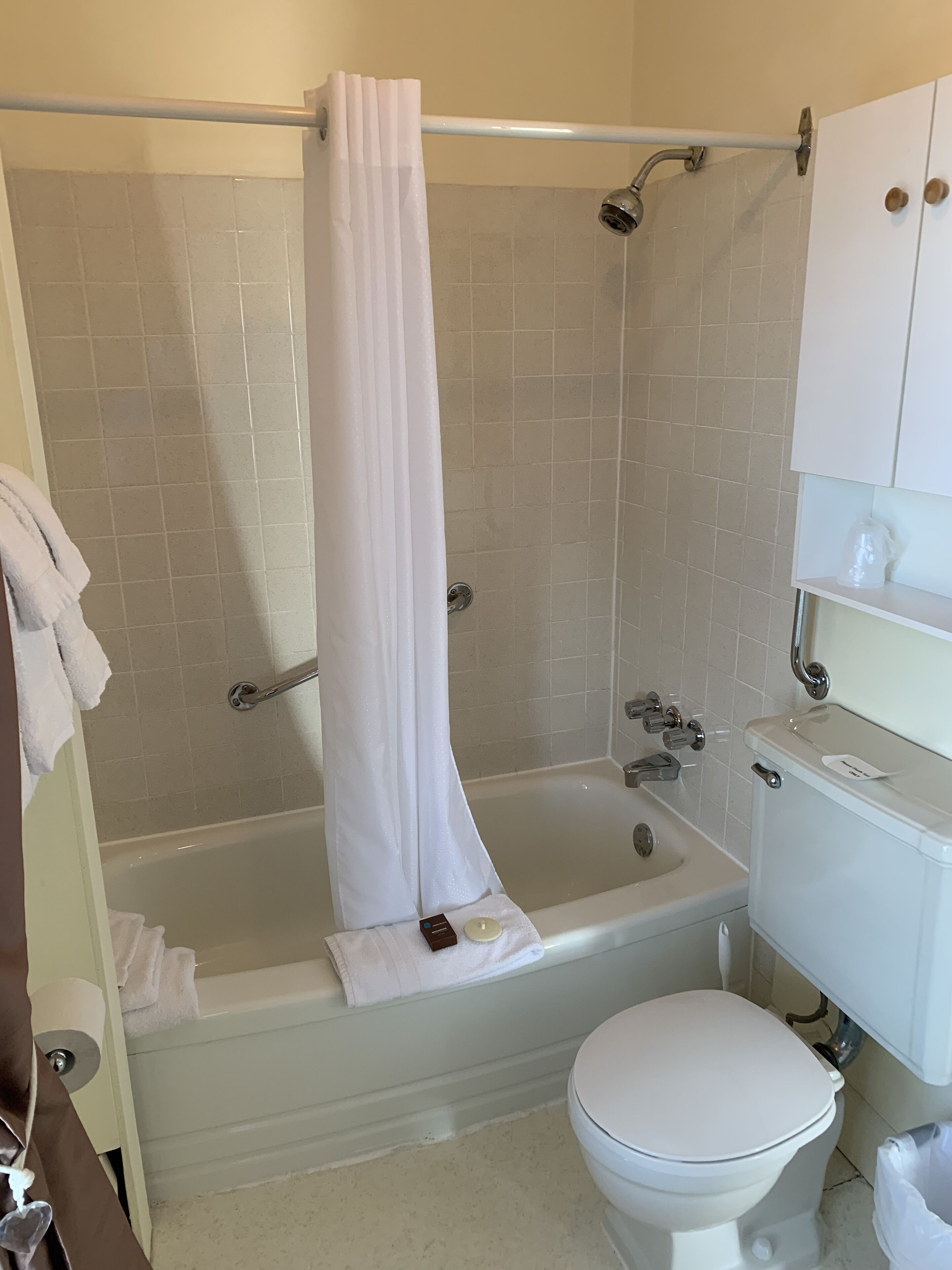 Une salle de bain avec une baignoire, des toilettes et un rideau de douche.