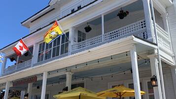 A two-story building with a balcony, a Canadian flag, and a sign for a restaurant.