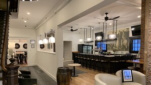 A modern bar area with a counter, stools, and pendant lighting. - Kennedy House (St. Andrews)