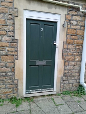 Traditional entrance to a residential unit with a small step and a paved path.