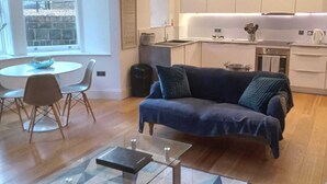 Una sala de estar moderna con sofá, mesa de centro y comedor.