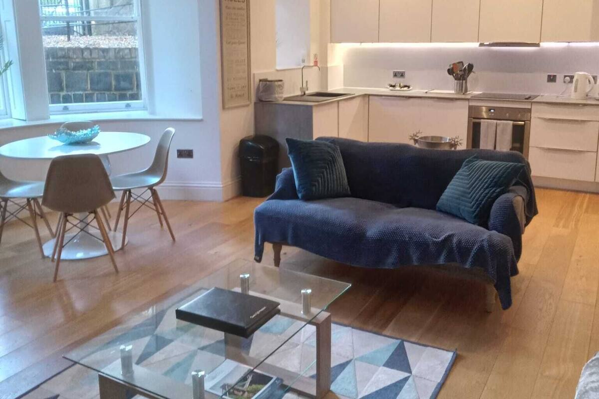 A modern living room with a sofa, coffee table, and dining area.