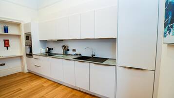 Een moderne keuken met witte kasten, een roestvrijstalen spoelbak en een ingebouwde oven.