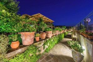 A terraced garden with potted plants and a wooden pergola. - B&B La Casa nel Giardino (Piano di Sorrento)