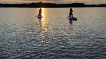 Un lago tranquilo al atardecer con dos kayaks.