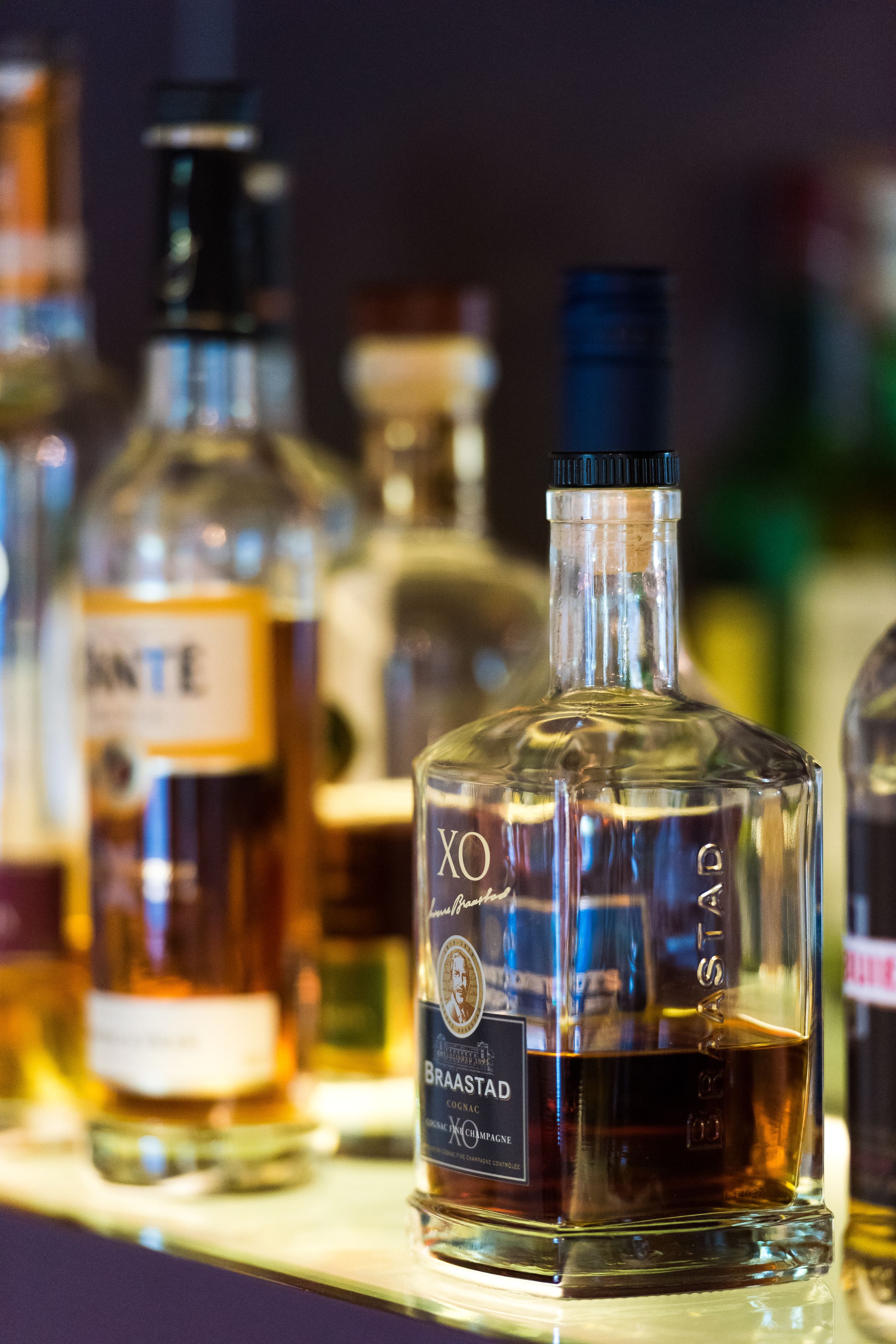 Variedad de botellas de licor en una estantería.