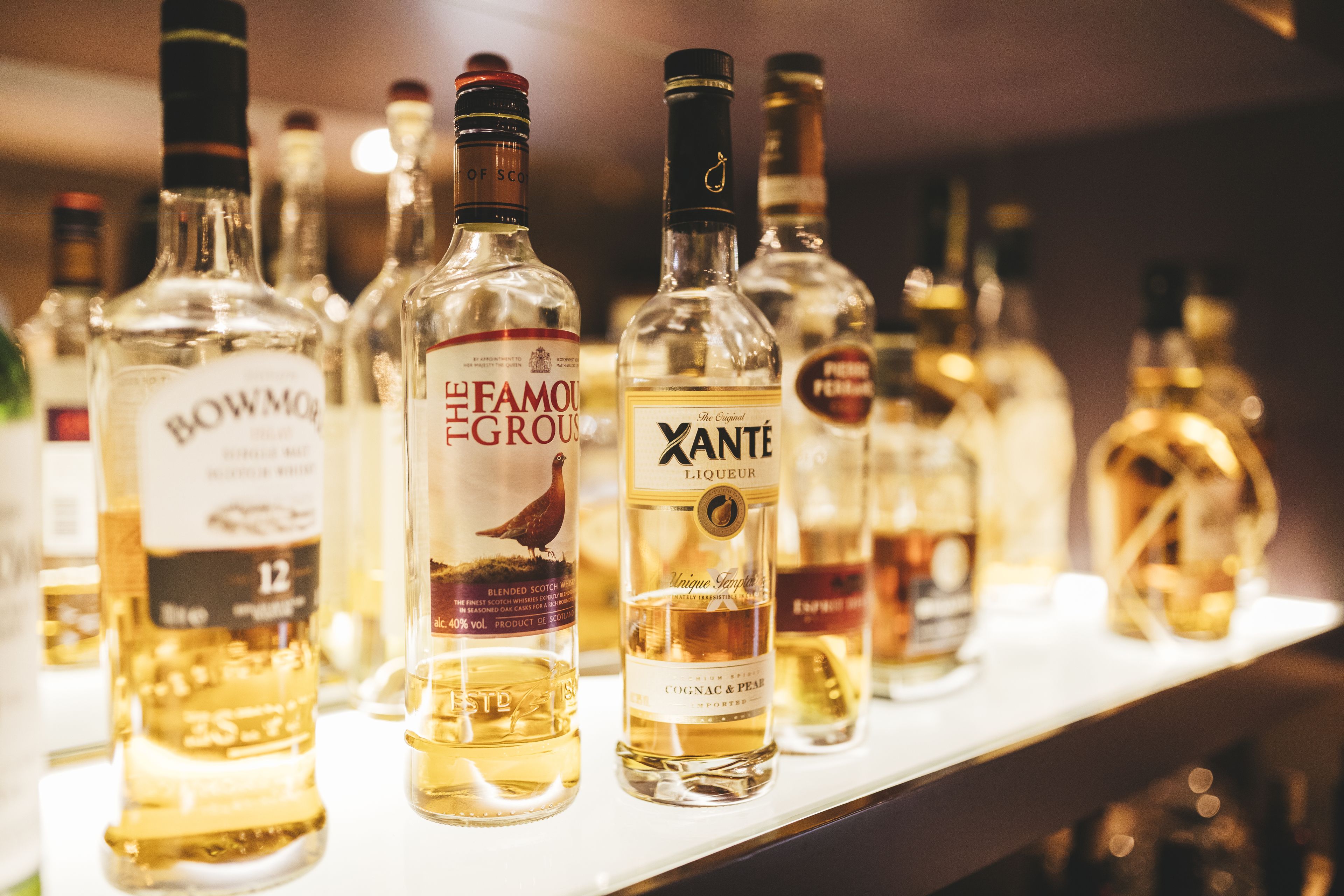 A row of liquor bottles on a shelf.