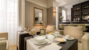 Un coin repas avec une table mise pour le petit-déjeuner, une horloge et une bibliothèque en arrière-plan.