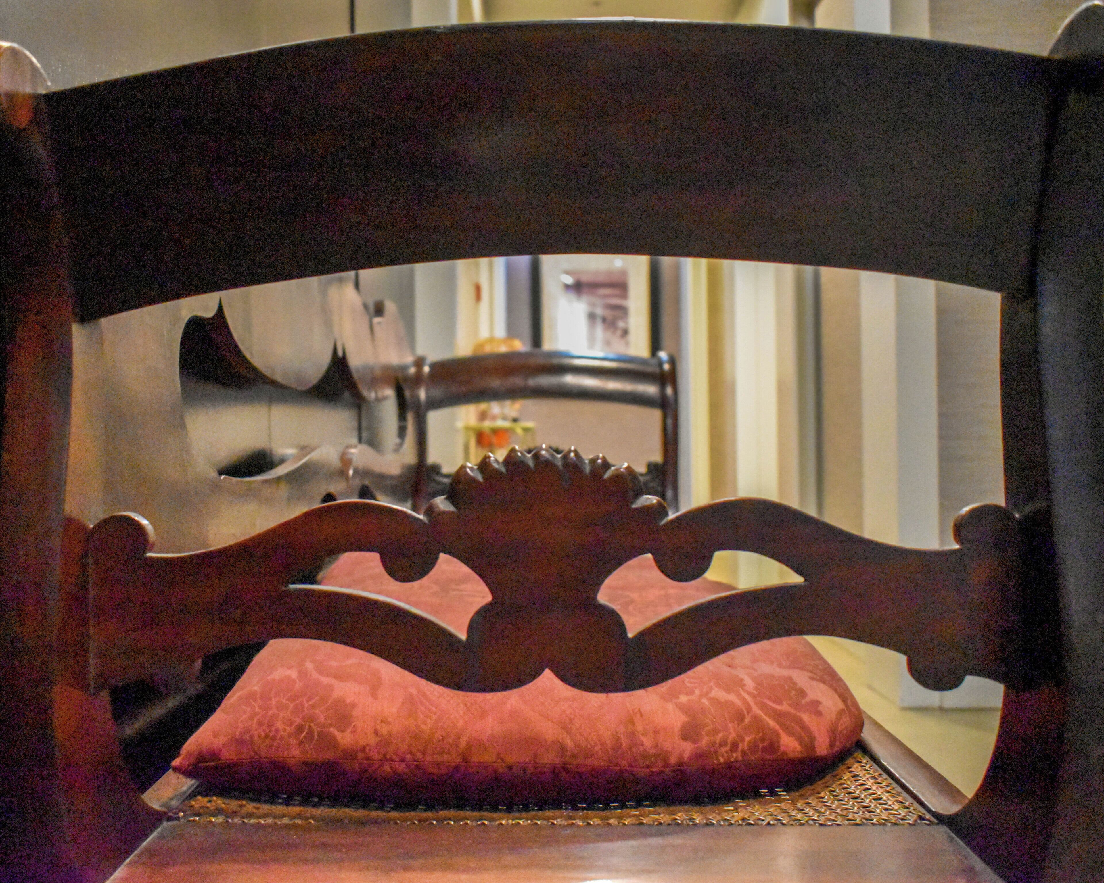Une chaise en bois dotée d’un siège et d’un dossier rembourrés.