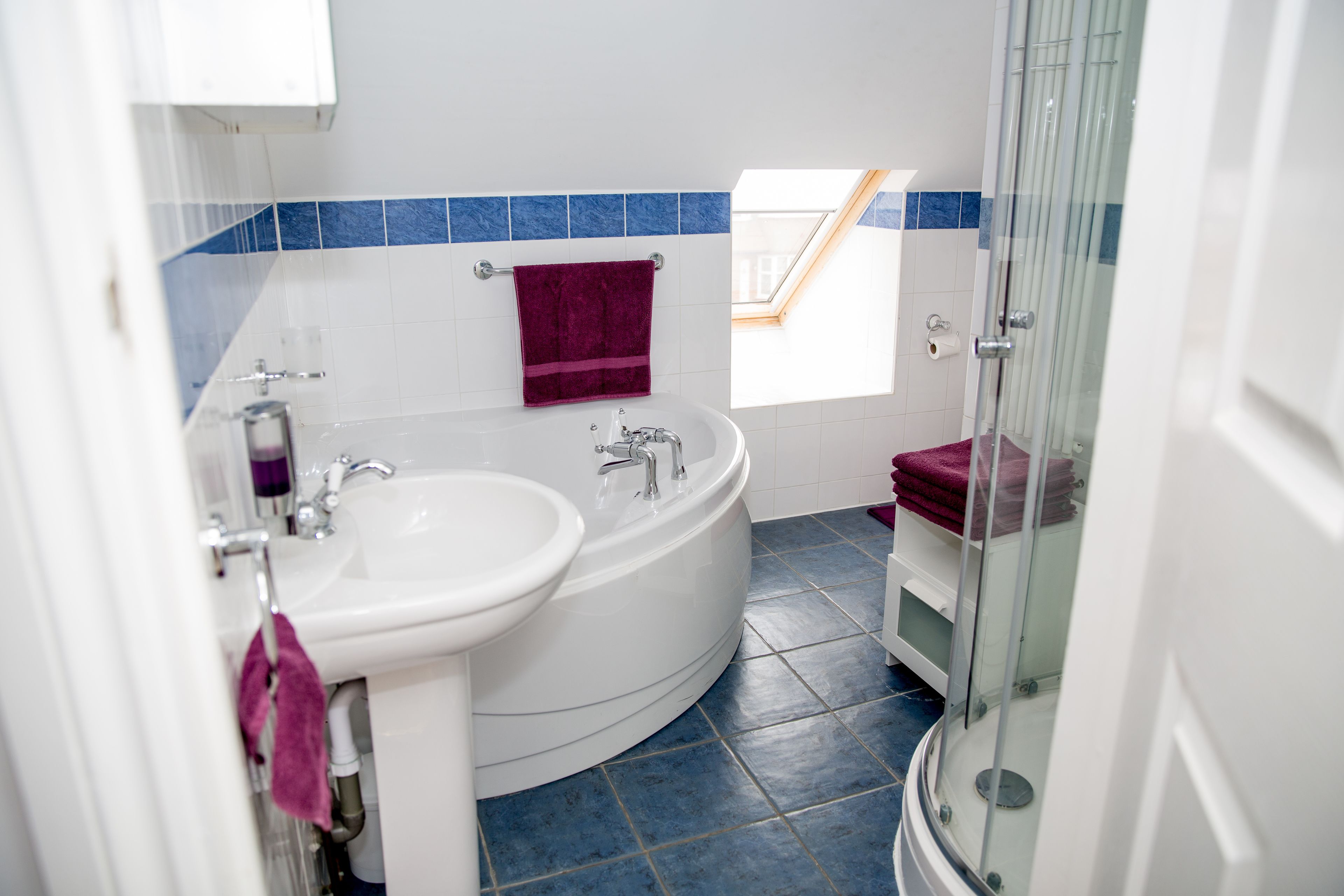 A bathroom with a white sink, a freestanding bathtub, and a glass-enclosed shower.