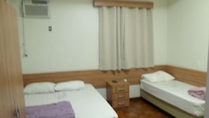 A room with two beds, a wooden wardrobe, a small wooden chest of drawers, and a window with curtains. - Hotel Pousada Clínicas Jardins Paulista (São Paulo)