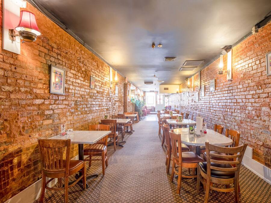 Un restaurante con paredes de ladrillo, mesas y sillas de madera.