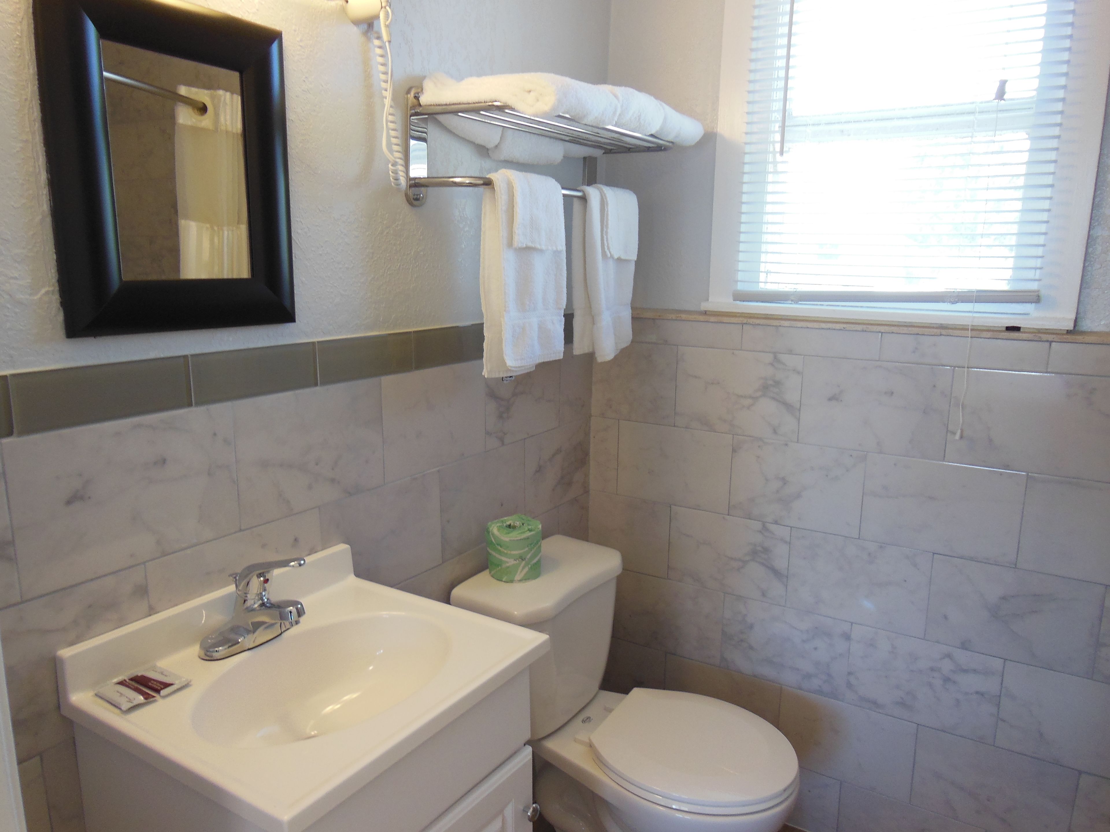 A bathroom with a sink, toilet, and a towel rack.