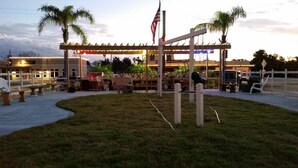 An outdoor seating area with tables and chairs, a covered pavilion, and an American flag. - Budget Inn St. Augustine (St. Augustine)