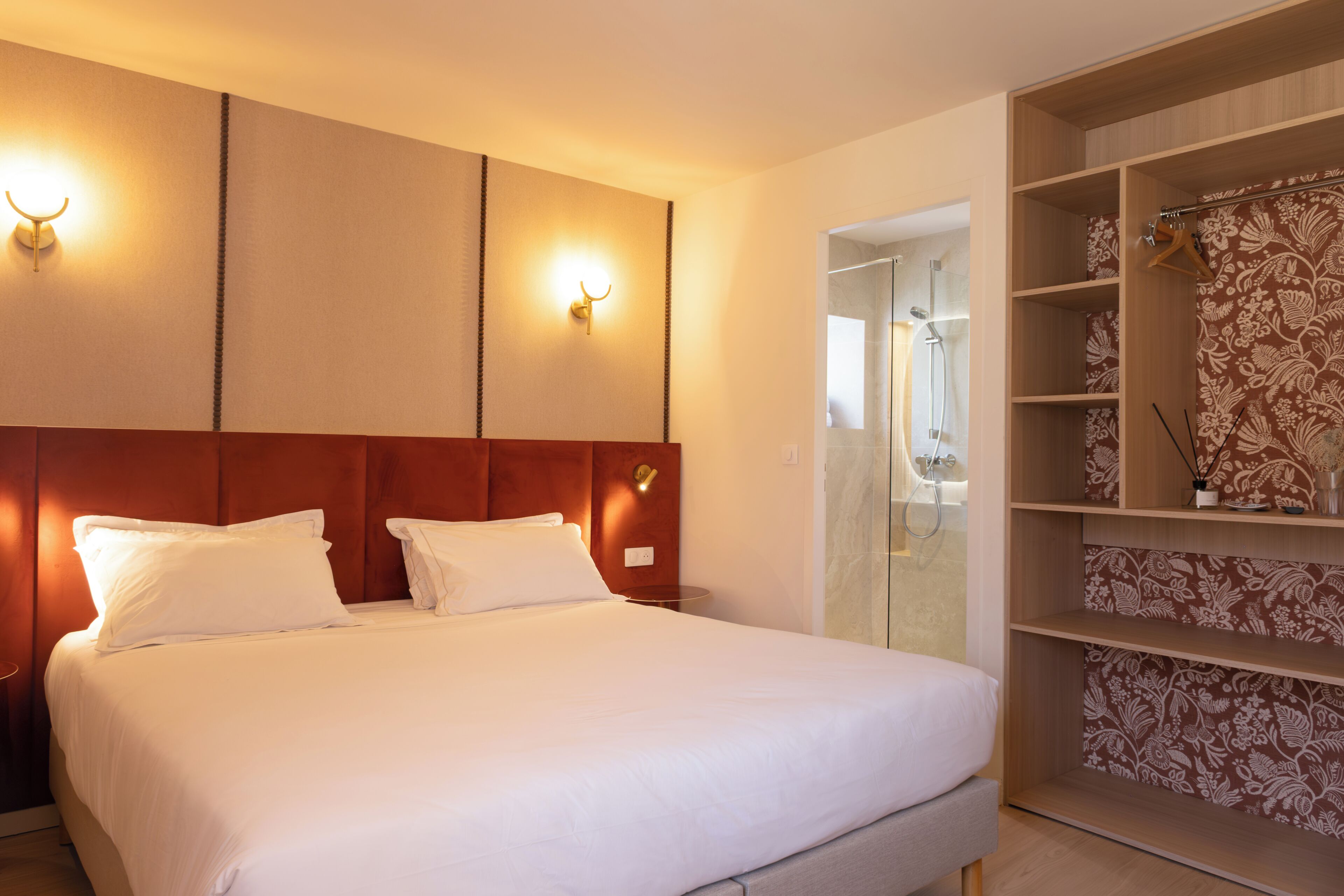 Een hotelkamer met een bed, een kledingkast en een badkamer, zichtbaar door een open deur.