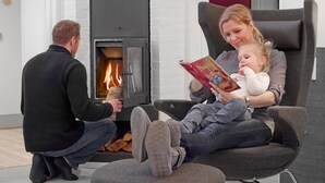 Una sala de estar acogedora con chimenea, un sillón cómodo y un sofá.