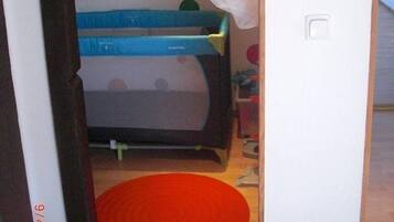 Un dormitorio infantil con una cama litera, una pared de lunares y una alfombra roja.