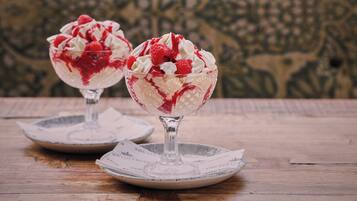 Zwei Dessertschalen auf einem Holztisch mit ornamentalem Hintergrund.
