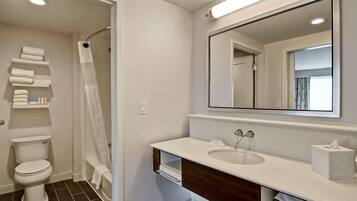A modern bathroom with a toilet, shower, and sink.