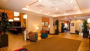 A hotel lobby with a reception desk, seating area, and a 'Welcome' mat. - Hampton Inn & Suites Huntsville (Huntsville)