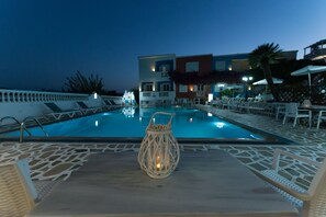 A swimming pool with lounge chairs and a decorative lantern.