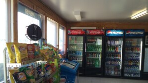 A snack and beverage vending area with various snack bags and a selection of sodas and bottled waters. - Glenhaven Motel (Saint Thomas)