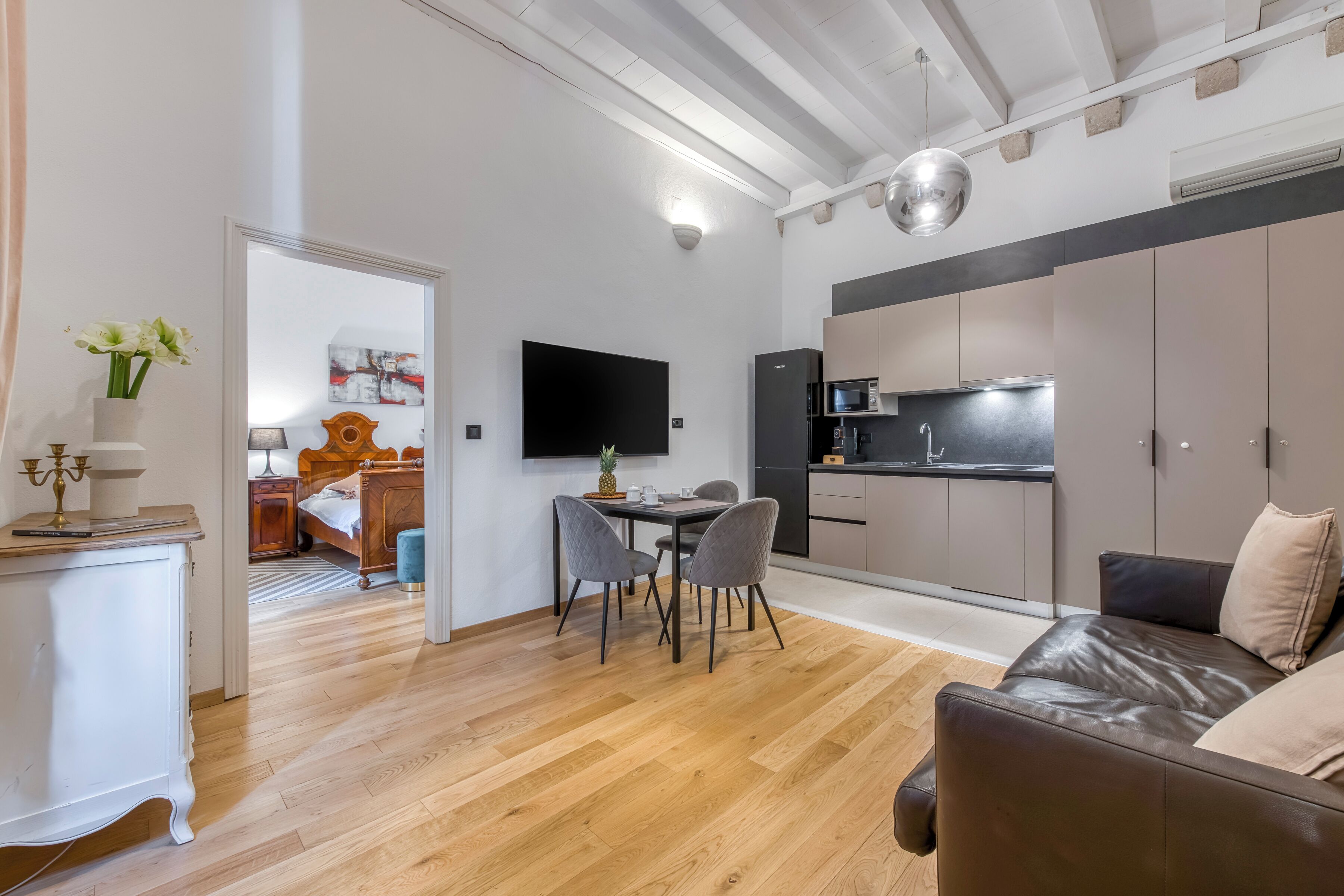 A modern living space with a dining area, kitchen, and a cozy seating area.