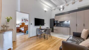 A modern living space with a dining area, kitchen, and a cozy seating area.