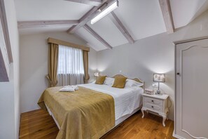 Une chambre à coucher avec un lit, une table de chevet, une lampe et une porte.