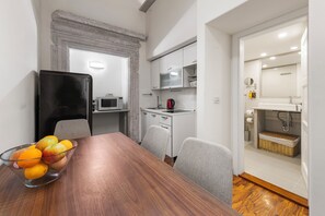 A compact kitchen with a microwave, kettle, and a small sink.