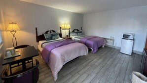 A small, clean room with two beds, a desk, a chair, and a refrigerator. - Castillo Inn (St. Augustine)