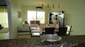 A modern kitchen with granite countertops, a stainless steel sink, and pendant lighting. - Unlimited Luxury Villas - Playa Royale Condo (Nuevo Nayarit)