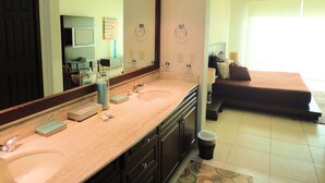 A bathroom with dual sinks, a large mirror, and a vanity with toiletries. - Unlimited Luxury Villas - Playa Royale Condo (Nuevo Nayarit)