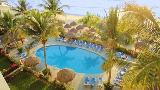 A pool area with lounge chairs and palm trees. - Unlimited Luxury Villas - Playa Royale Condo (Nuevo Nayarit)