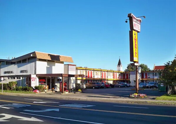 Un motel con un edificio central y una hilera de habitaciones contiguas.