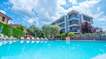 季节性开放的室外游泳池，池畔遮阳伞，日光浴躺椅