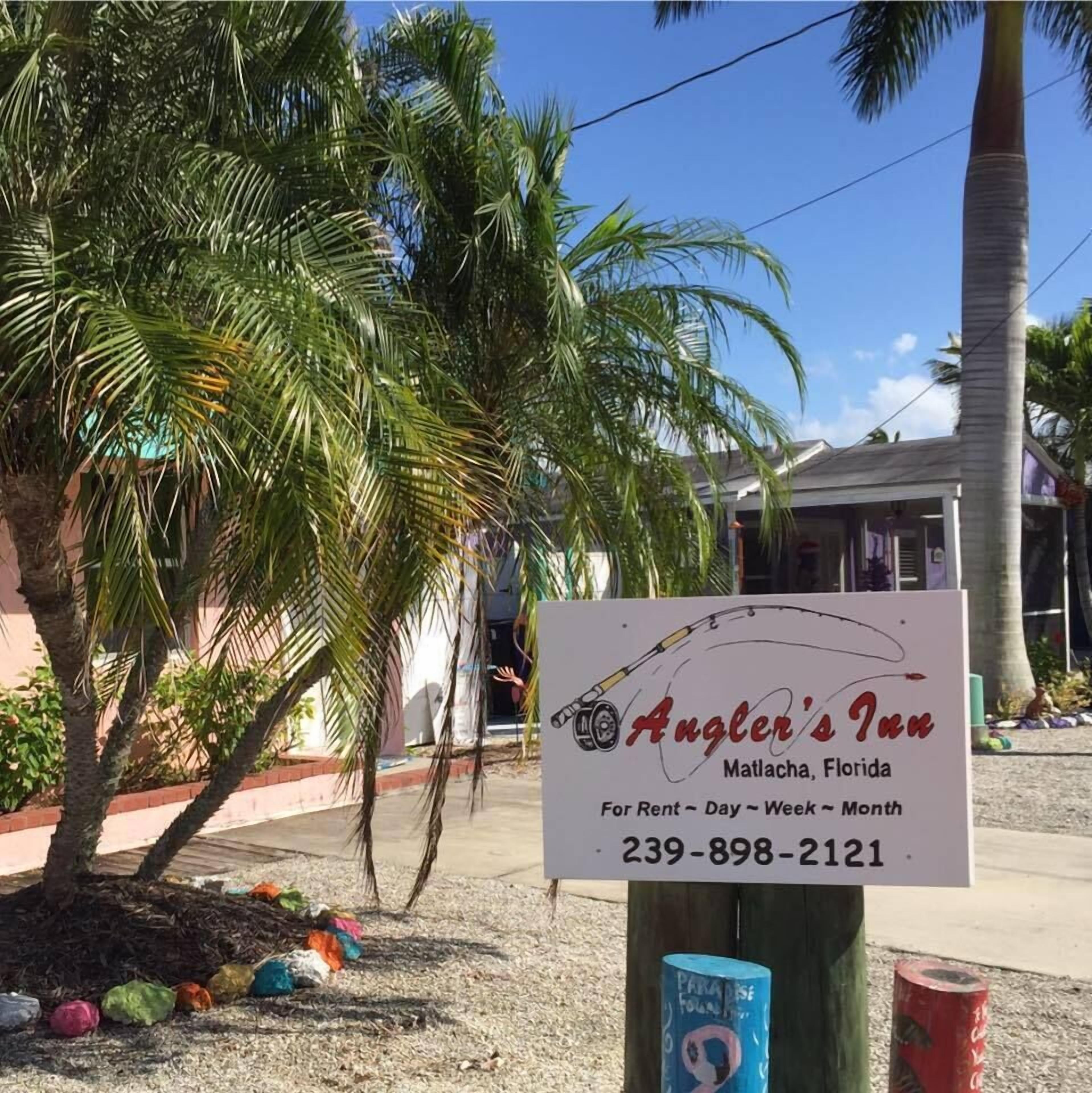 Letrero de Angler's Inn en Matlacha, Florida, anunciando disponibilidad para alquiler por día, semana o mes.