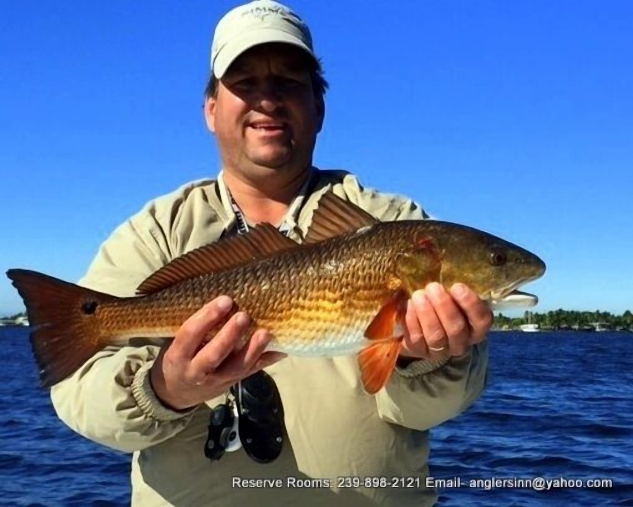 A person holding a fish on a boat.