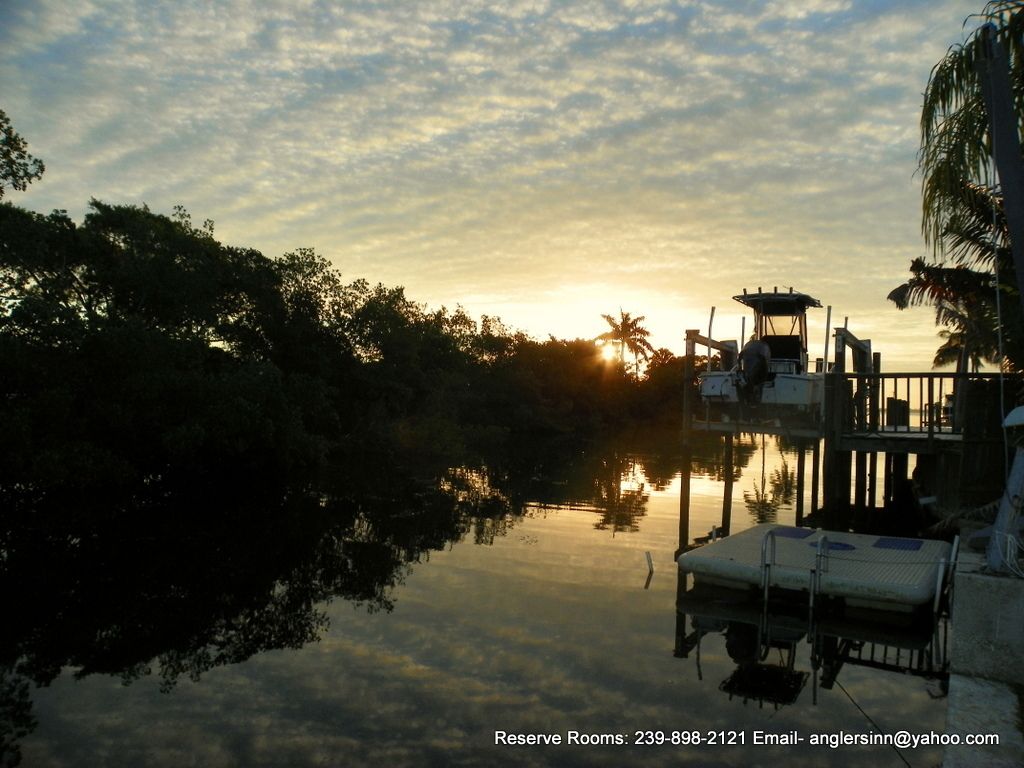 A serene waterfront scene with a dock and lounge chairs.