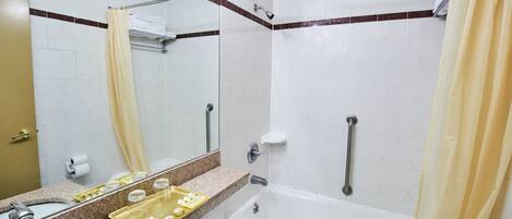 A bathroom with a sink, mirror, bathtub, and shower.