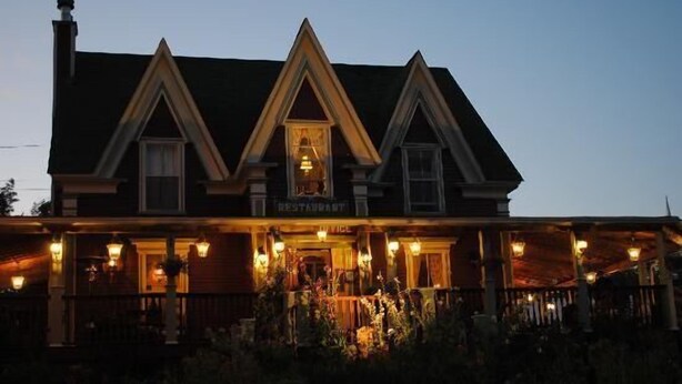 A large, two-story building with a prominent 'RESTAURANT' sign at the entrance. - Lynwood Inn (Baddeck)