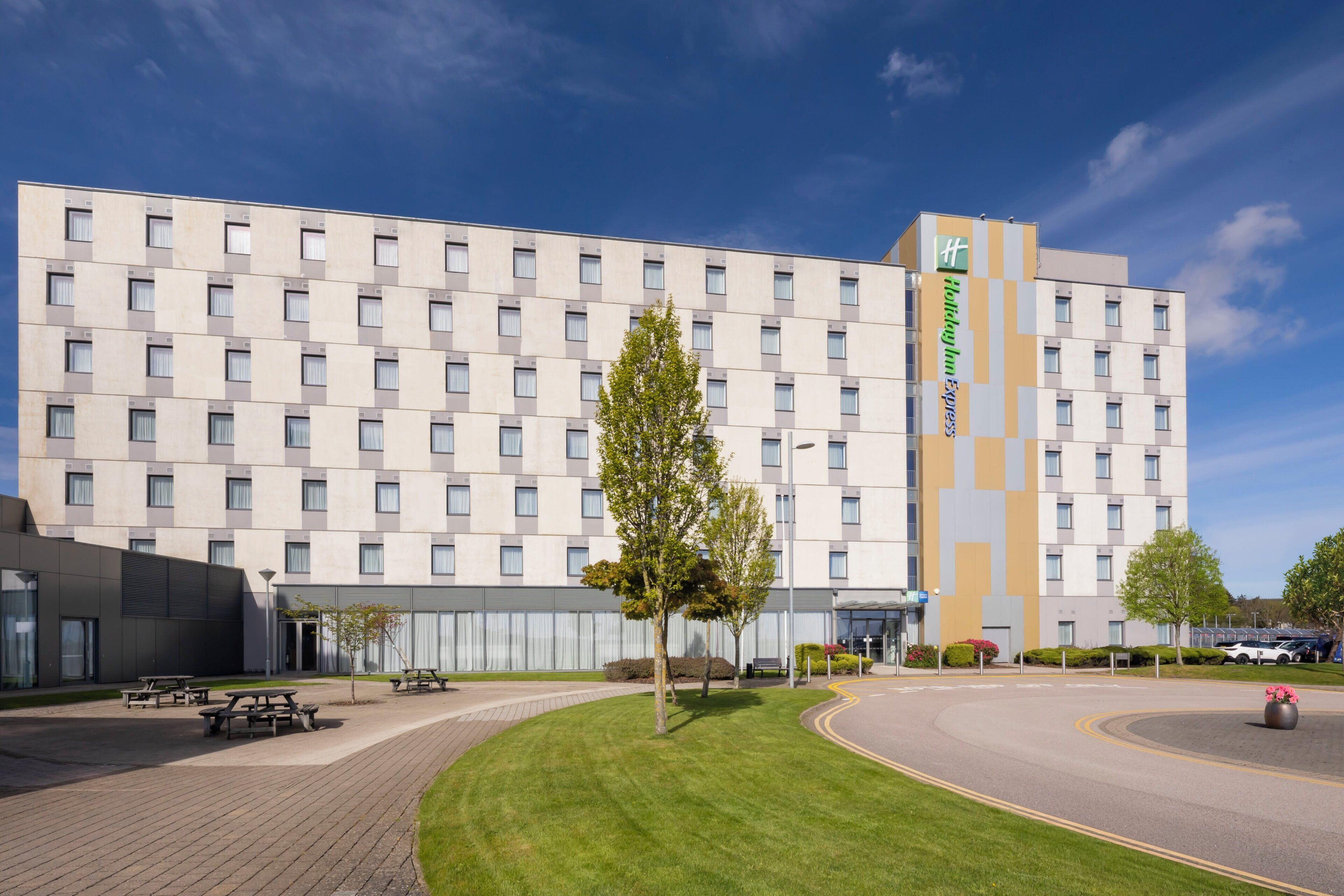 Een modern hotel met een platte gevel, meerdere ramen en een centrale ingang.