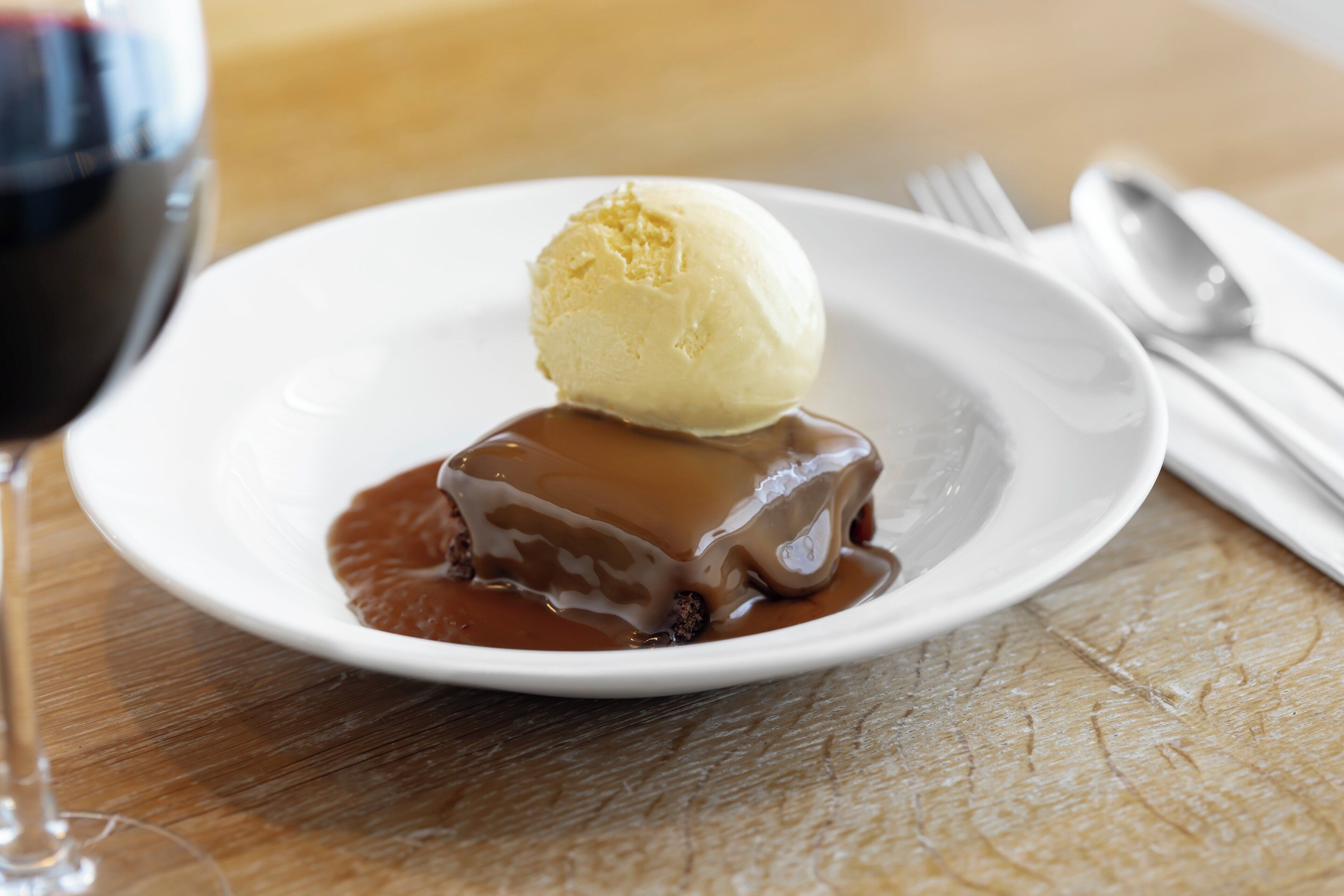 A dessert plate with a scoop of ice cream and a chocolate dessert on a white plate.