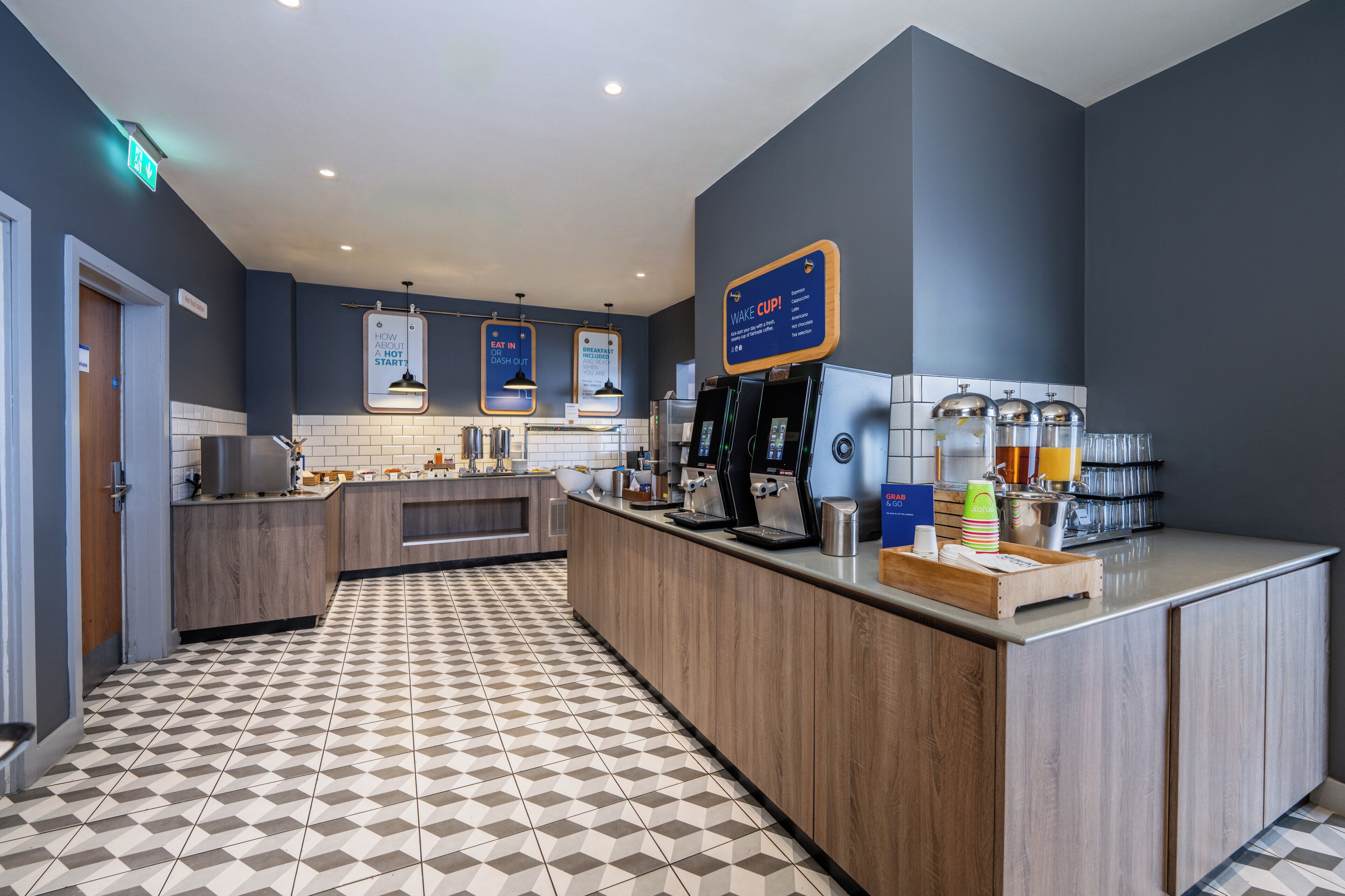 A modern kitchen with a coffee station, a microwave, and a coffee machine.