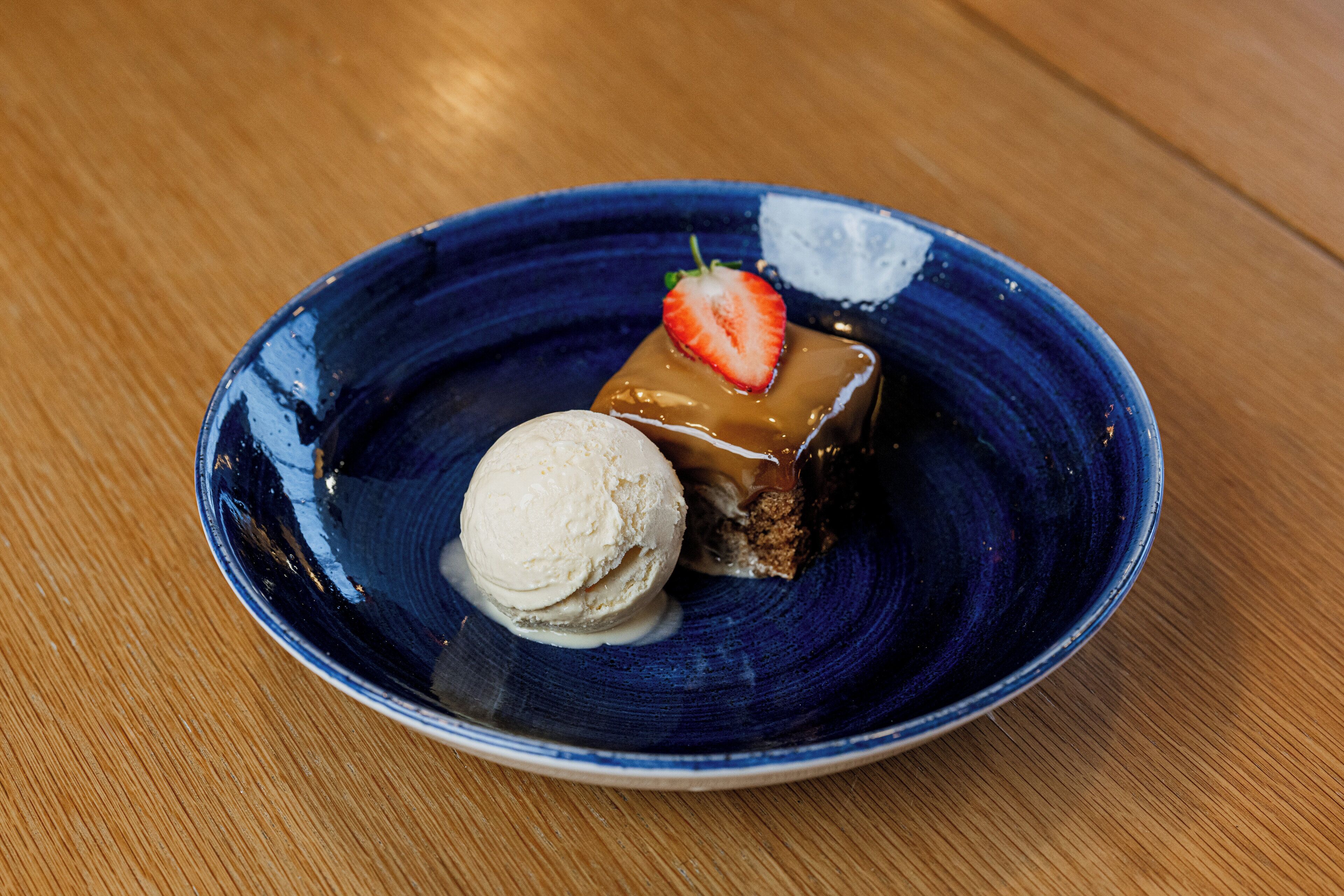 A dessert on a blue plate with a wooden table background.