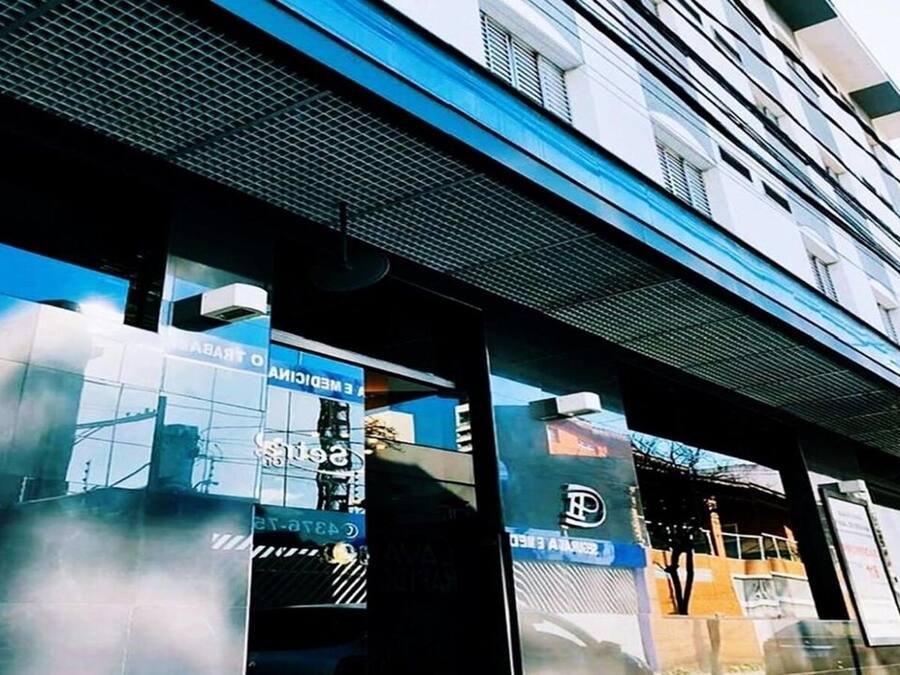 Un edificio con ampie finestre che riflettono lo skyline della città.