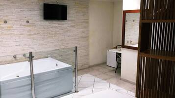 A modern bathroom with a bathtub, a toilet, a sink, and a mirror.