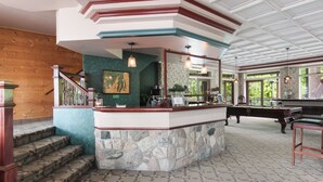 A bar area with a stone counter, wooden steps, and a view of the outdoors. - Stone Waters Inn (Bellaire)